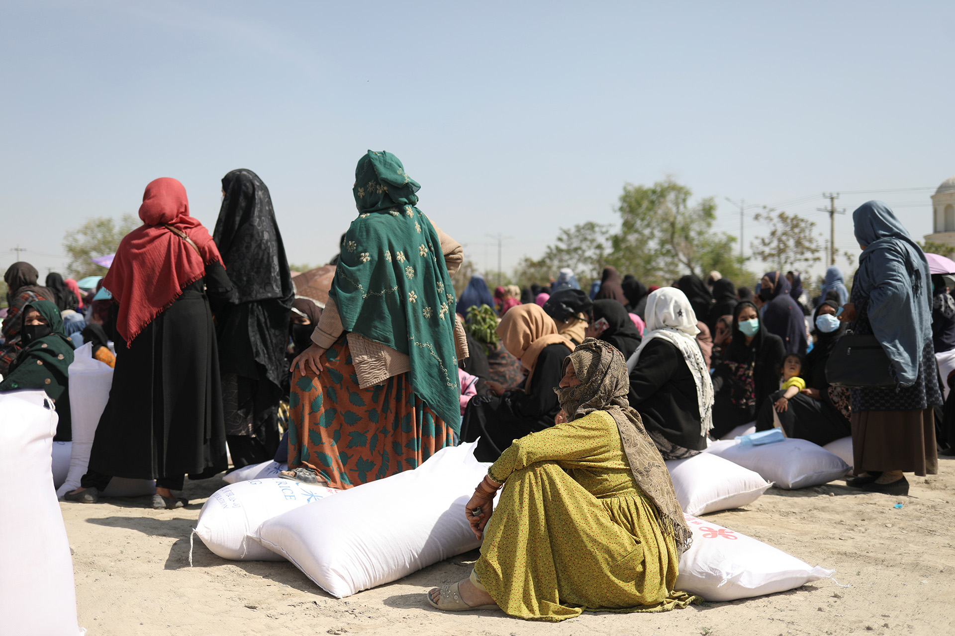 Women receive sacks of rice sent by China at a Kabul distribution centre in April 2022. Between July 2021 and March 2022, the number of Afghans facing acute hunger rose from 14 million to 23 million. 