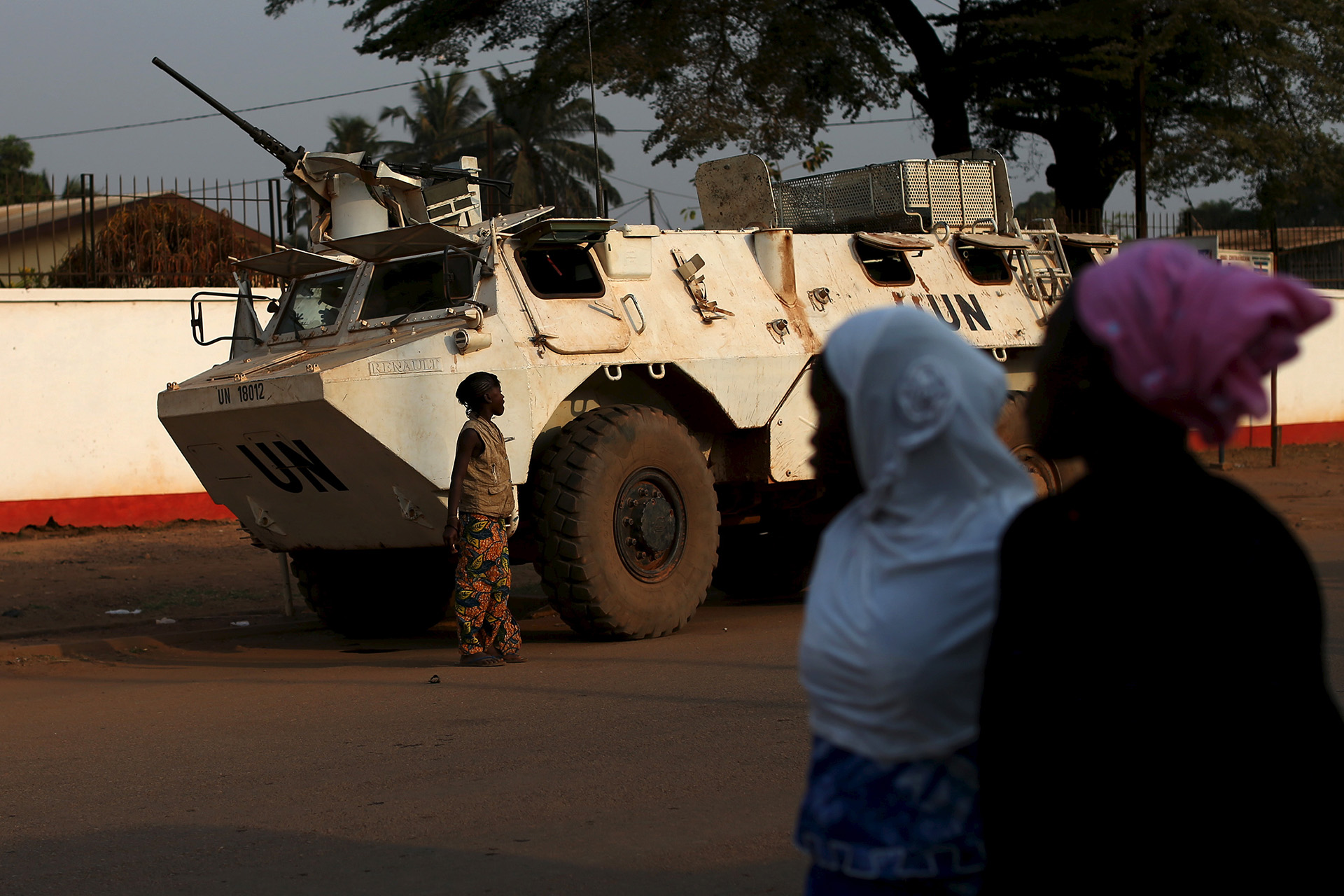 Civilian women out of focus in the foreground walk in front of a UN tank in Central African Republic.