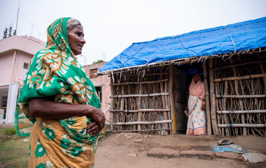 A Dalit woman standing outside her house, which has a blue tarpaulin roof, typical of Dalit houses in Narasinghpatana, in the eastern state of Odisha, where many are still awaiting government compensation three years after disaster struck.