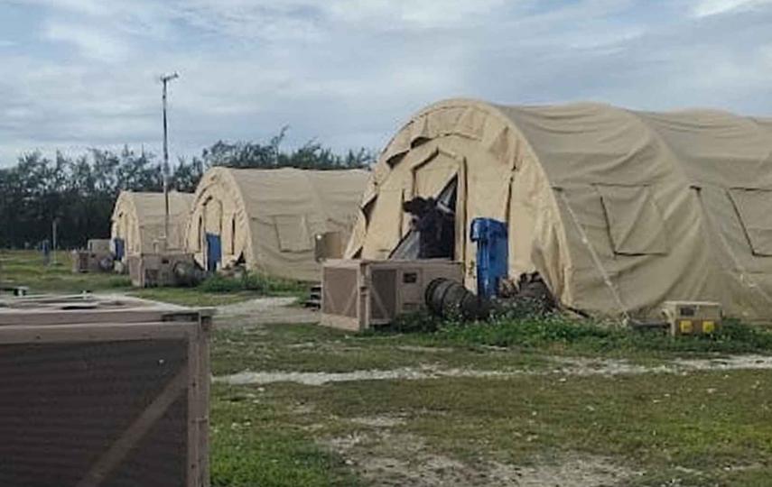 Medium shots of beige colored tents on sparse grass. These tents are part of an encampment on Diego Garcia, where 68 Sri Lankan asylum seekers have been living for months.