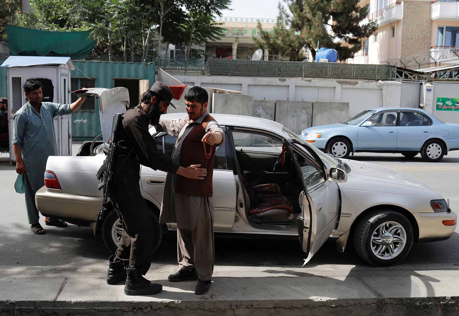 A Taliban soldier checks a man at a checkpoint in Kabul, Afghanistan, July 6, 2023.