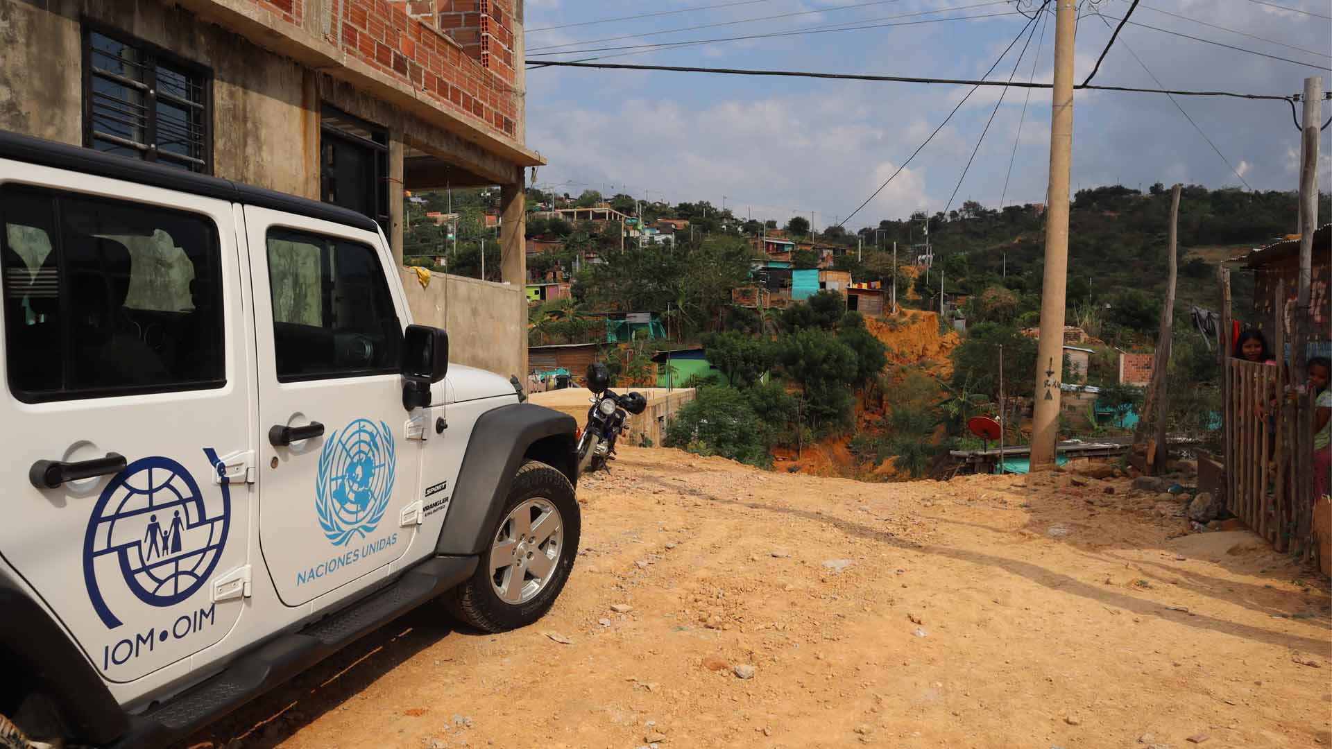 A car from the International Migration Organization is parked in front of a house in the Alfonso Gómez settlement.